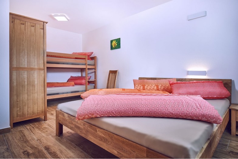 Schlafzimmer mit Doppelbett und Stockbett (Appartement 1)