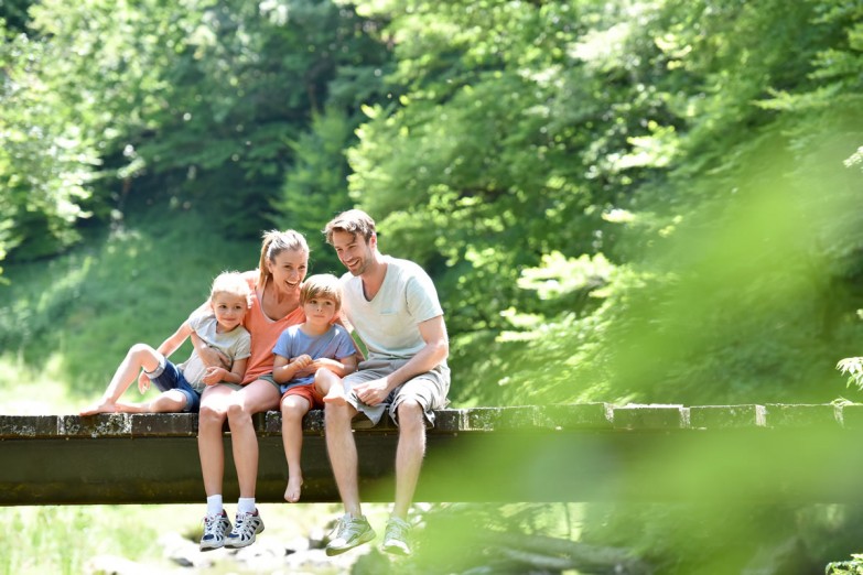 Familie entspannt auf einer Brücke © shutterstock.com